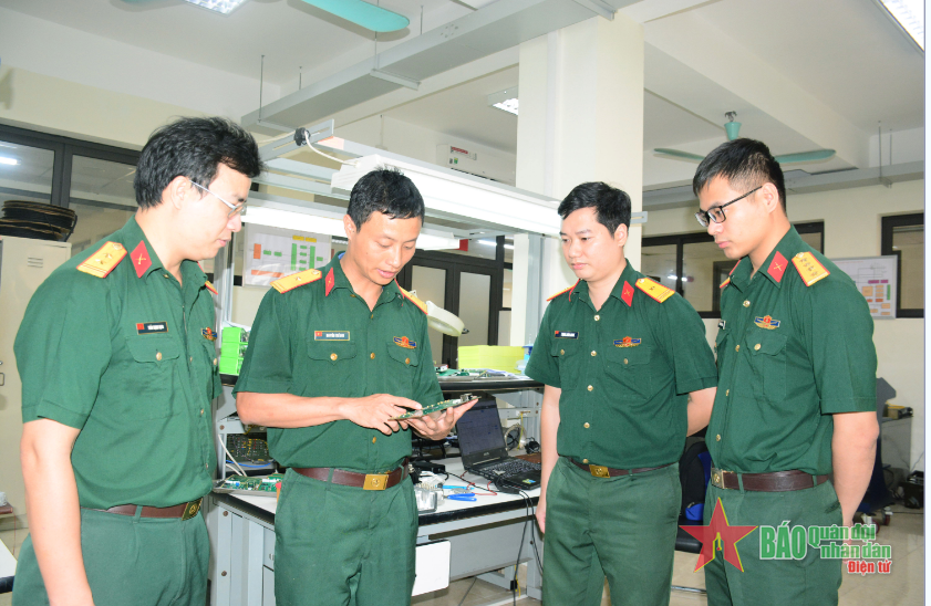  Thiếu tá Nguyễn Thế Duy (thứ hai, từ trái sang), Trung tâm 80, Cục Tác chiến điện tử trao đổi chuyên môn với các đồng đội.
