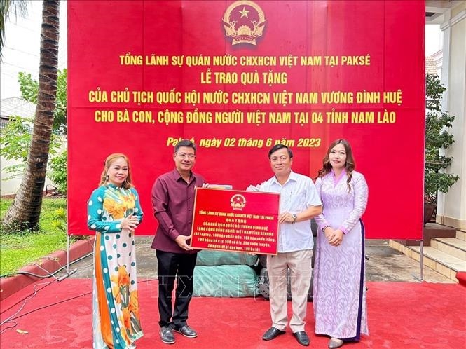 Đại diện Tổng lãnh sự quán Việt Nam tại Pakse trao quà của Chủ tịch Quốc hội cho đại diện cộng đồng người Việt tại tỉnh Sekong. Ảnh: TTXVN