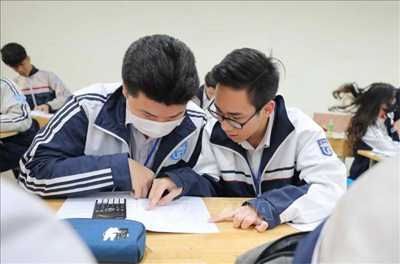 Học sinh khối 12 trường THPT Trương Định (quận Hoàng Mai) trao đổi bài trong giờ ôn tập kiến thức cho kỳ thi tốt nghiệp THPT năm 2023. Ảnh: TTXVN 