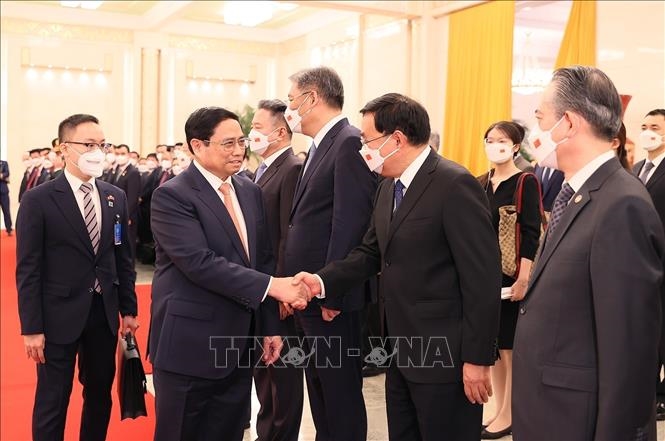 Thủ tướng Lý Cường giới thiệu các thành viên Đoàn đại biểu Trung Quốc với Thủ tướng Phạm Minh Chính. 