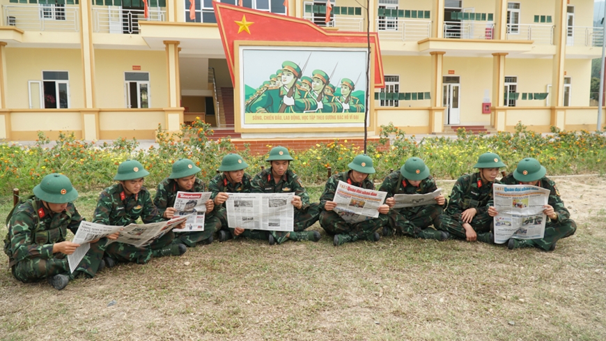 Chiến sĩ Trung đoàn 244 (Bộ CHQS tỉnh) tranh thủ đọc báo trong giờ nghỉ giải lao ở thao trường. Ảnh: baoquangninh.vn