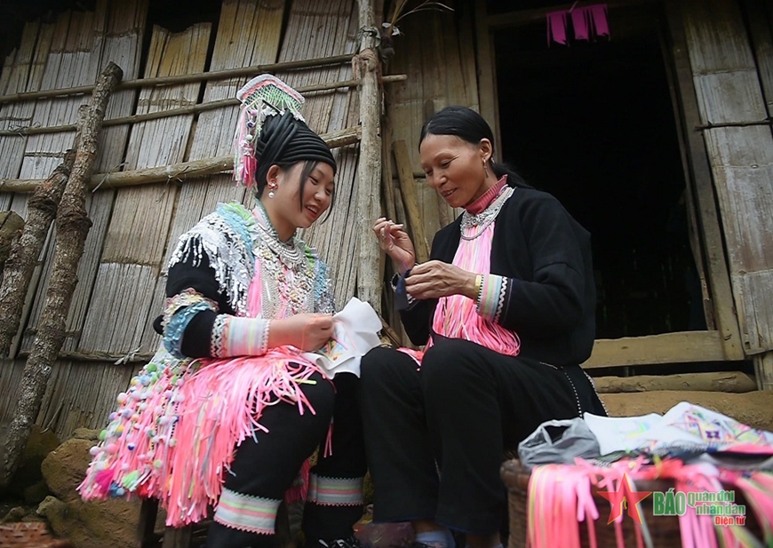  Mẹ dạy con thêu hoa văn trên áo.