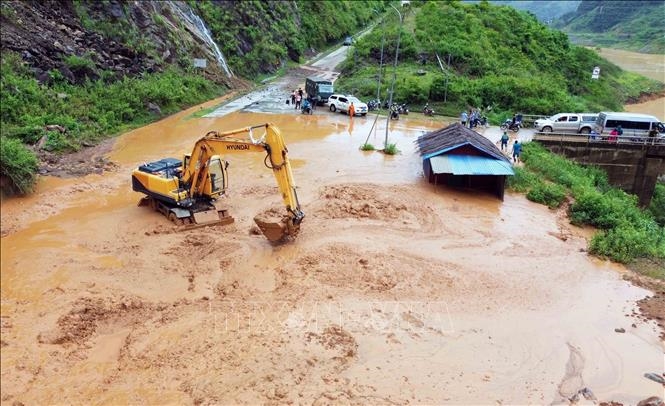 Máy múc được huy động để san gạt bùn, đất, đá bị sạt lở tại bản Nà Lếch, xã Chiềng Lao, huyện Mường La. Ảnh: TTXVN 