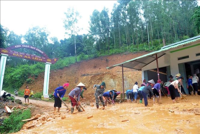Người dân bản Nà Lếch, xã Chiềng Lao, huyện Mường La san gạt bùn, đất, đá bị sạt lở vào nhà. Ảnh: TTXVN 