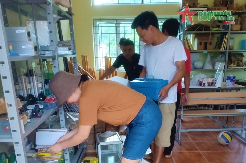 Các thầy cô trường THCS Nậm Cha thu dọn đồ đạc tại phòng có nguy cơ bị sạt lở đến nơi an toàn.