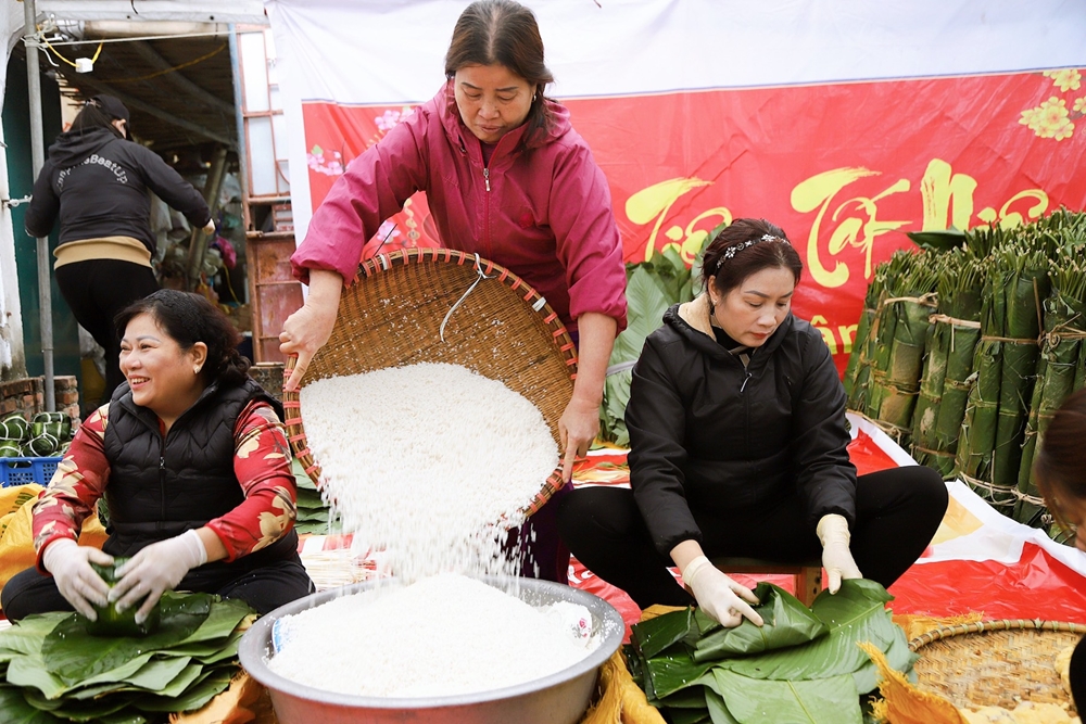 Không khí nhộn nhịp, mỗi người một công đoạn để tạo thành một chiếc bánh chưng làng Tranh Khúc hoàn chỉnh.