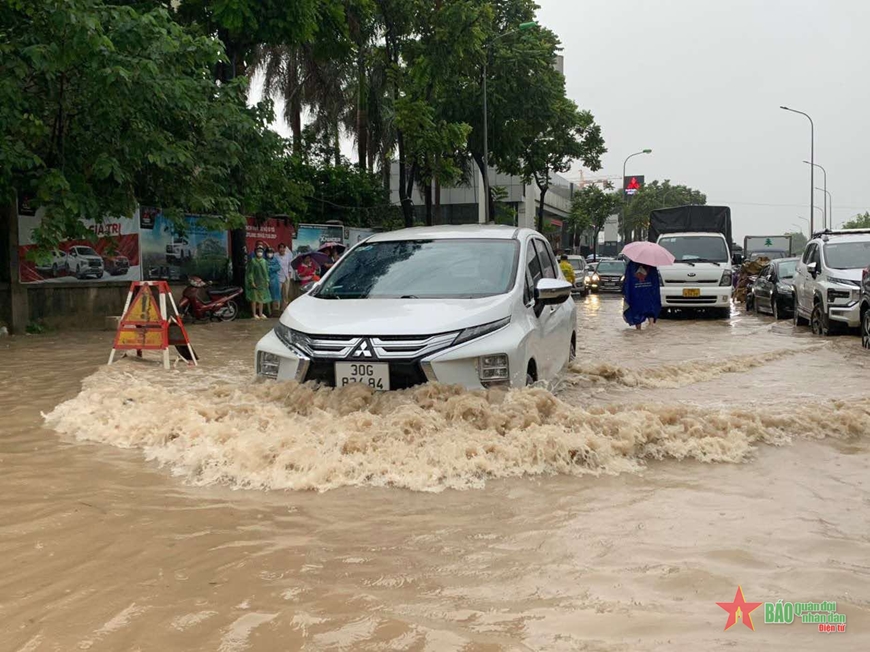 Cảnh sát giao thông Hà Nội bố trí lực lượng hỗ trợ người dân qua những điểm ngập lụt