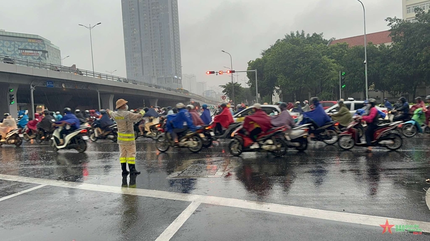 Cảnh sát giao thông Hà Nội bố trí lực lượng hỗ trợ người dân qua những điểm ngập lụt
