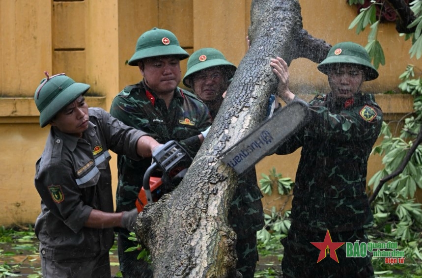 Cán bộ, chiến sĩ Lữ đoàn 144, Bộ Tổng Tham mưu QĐND Việt Nam khắc phục hậu quả bão số 3 trên phố Nguyễn Tri Phương (Ba Đình, Hà Nội). Ảnh: VIỆT TRUNG