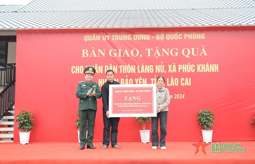 Thượng tướng Hoàng Xuân Chiến trao quà tặng thôn Làng Nủ. 