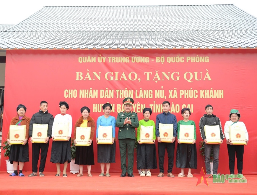 Thượng tướng Hoàng Xuân Chiến trao quà tặng người dân thôn Làng Nủ. 