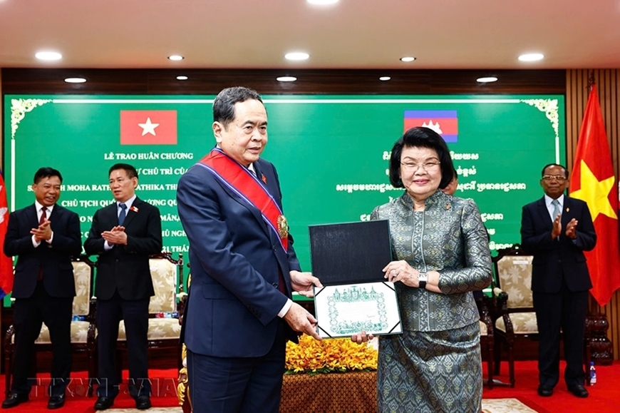 Chủ tịch Quốc hội Campuchia Samdech Khuon Sudary đeo dải băng, trao Giấy chứng nhận Huân chương Đại thập tự tặng Chủ tịch Quốc hội Trần Thanh Mẫn. Ảnh: TTXVN