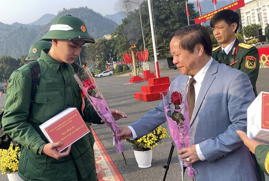 Đồng chí Tống Thanh Hải và lãnh đạo thành phố Lai Châu, đại diện lực lượng vũ trang tặng hoa, quà động viên thanh niên nhập ngũ trong buổi lễ giao nhận quân.