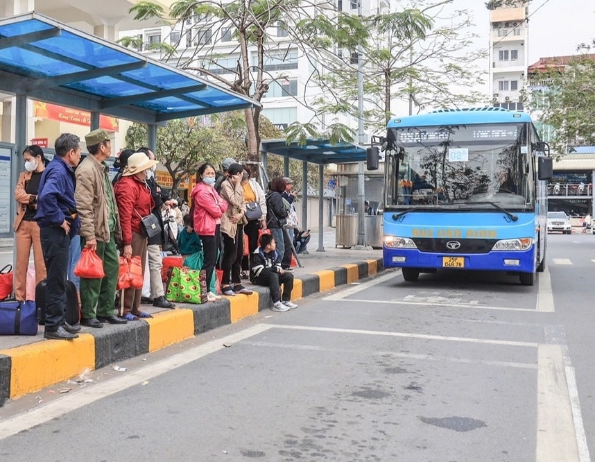 Hành khách đón xe buýt tại bến xe ở Hà Nội. 