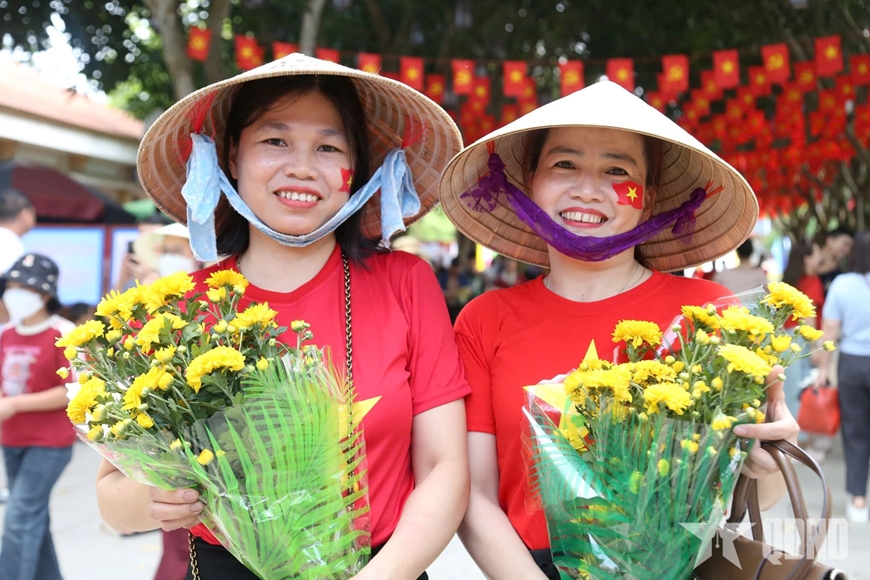 Người dân với màu áo đỏ, sao vàng cùng những bông hoa tươi thắm tưởng nhớ Bác Hồ.