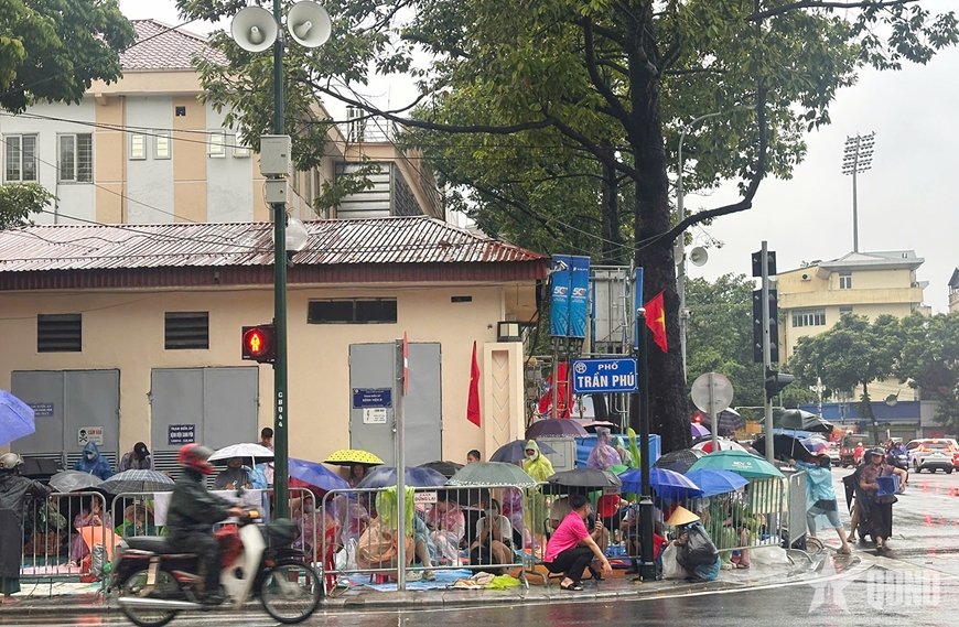 Dù trời mưa, người dân trải bạt giữ chỗ chờ xem Lễ sơ duyệt diễu binh, diễu hành A80