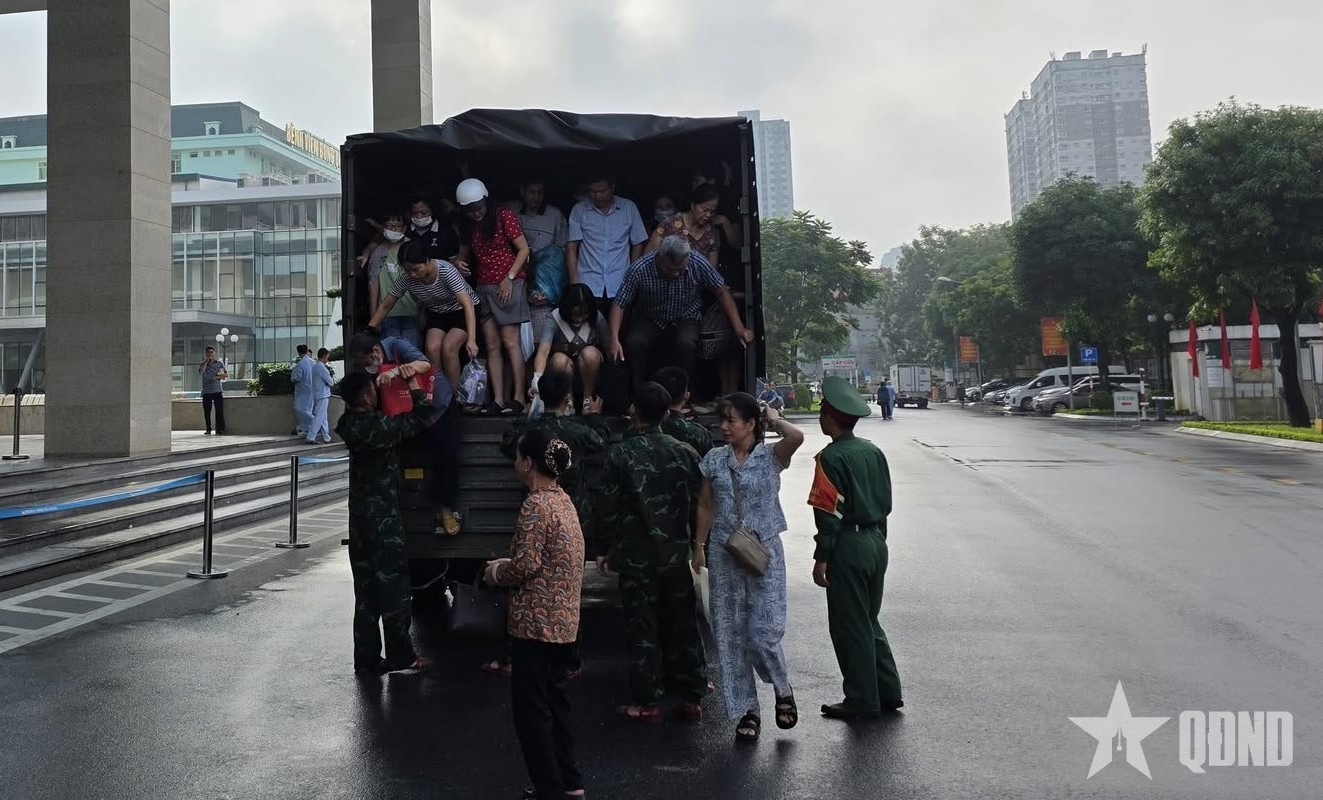 Hà Nội: Cán bộ, chiến sĩ Học viện Quân y giúp dân đi qua vùng ngập nước

