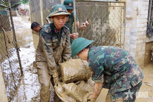 Troops strive to help locals clean up after flood