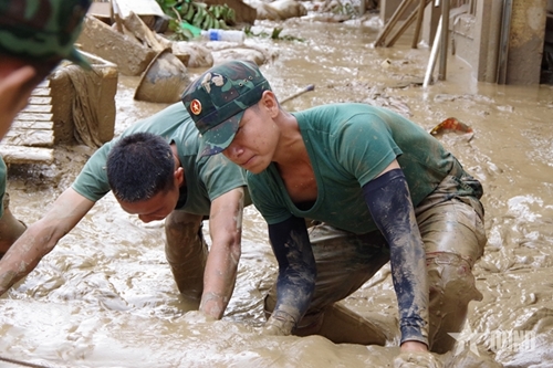Troops strive to help locals clean up after flood