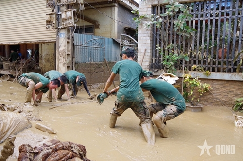 Troops strive to help locals clean up after flood