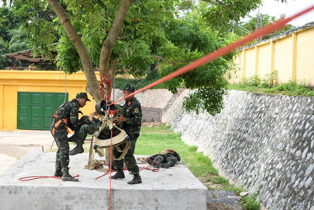 Các vận động viên tập luyện mắc dây ròng rọc vận chuyển thương binh qua sông.