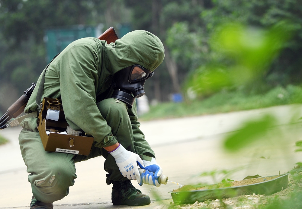 Thành viên đội tuyển thực hiện lấy mẫu khu vực nhiễm chất độc tại thực địa.