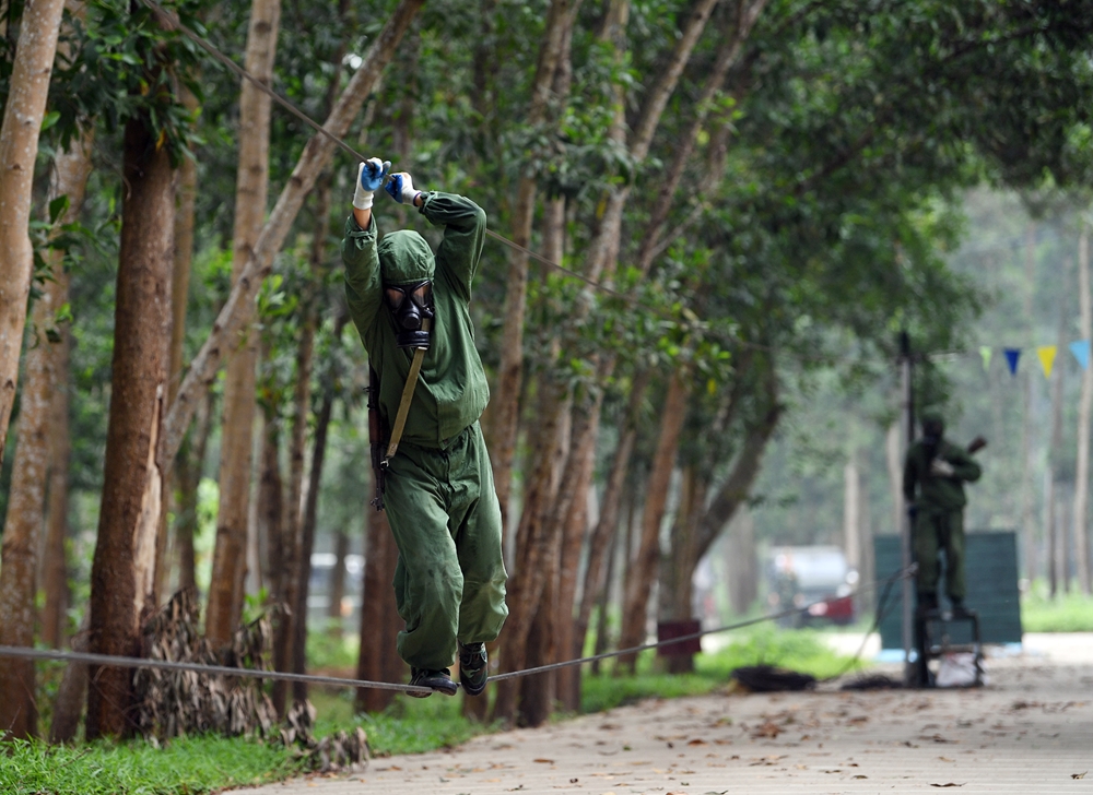 Các vận động viên vận động trên quãng đường 550m vượt qua 12 vật cản. Trong ảnh vận động viên kíp xe số 1 đang thực hiện đi trên dây vượt sông.