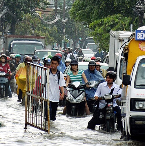 Triều cường lên vào giờ tan tầm khiến người dân đi lại rất khó khăn.