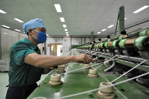 Công nhân Nguyễn Đình Thiều vận hành máy sợi thô