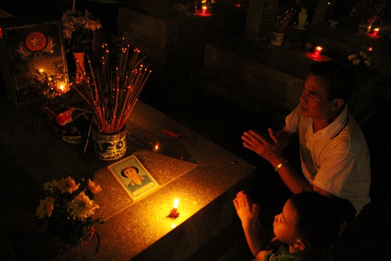 Bác Nguyễn Đắc Nam, người dân TP Hạ Long cùng cháu nội bên phần mộ của anh trai-liệt sĩ Nguyễn Đắc Đông, hy sinh năm 1968