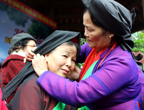 Hai liền chị vấn khăn mỏ quạ giúp nhau, trước khi vào hát