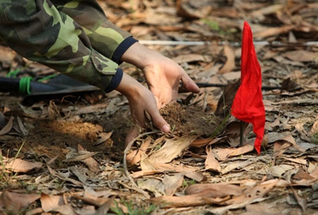 Gạt từng mẩu đất để tránh kích nổ mìn.