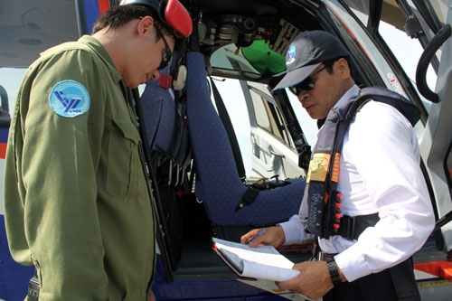 Phản ánh về cường độ làm việc rất cao của các tổ bay và các thành phần bảo đảm, Đại tá Trần Xuân Dinh-Giám đốc Công ty Trực thăng miền Bắc đã đùa vui: “Tất cả chúng tôi đều làm việc 1/1, vì thế không ai được phép…ốm”. Do yêu cầu nhiệm vụ nên lãnh đạo, chỉ huy của Công ty vẫn thường xuyên tham gia hoạt động bay, bởi họ là những người có trình độ, năng định bay tốt. Trong ngày bay hôm nay, 3 cán bộ trong Ban giám đốc Công ty đều tham gia. Đó là Đại tá Trần Xuân Dinh (bên phải)…