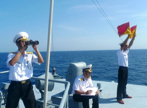 Thực hiện huấn luyện thu phát tín hiệu cờ tay với tàu Trung Quốc. Nhân viên tín hiệu, Trung úy Nguyễn Văn Thành đảm nhiệm việc phát cờ; Thượng úy Nguyễn Trung Kiên đọc điện; Trung tá Ngô Xuân Dưỡng, Trưởng ban thông tin Lữ đoàn, cầm ống nhòm giám sát quá trình huấn luyện. Quá trình luyện tập thu phát tín hiệu cờ tay diễn ra trong điều kiện thời tiết thuận lợi, đạt kết quả tốt.