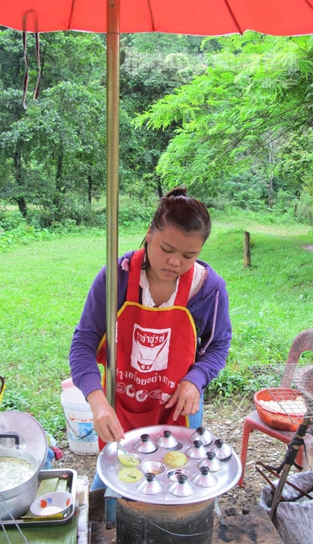 Một thiếu nữ đang làm bánh từ ngô và khoai.