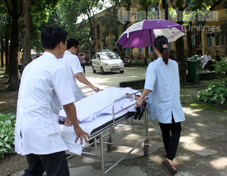 Sự ân cần của các thầy thuốc Bệnh viện Quân y 105 đối với bệnh nhân thể hiện từ những điều nhỏ nhất-cầm ô che nắng cho bệnh nhân trong quá trình đưa đón họ.