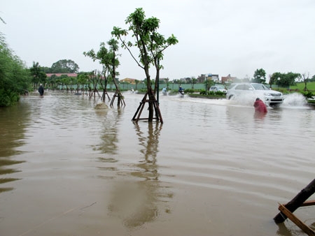 Sáng 9-8, từ đê sông Hồng (hướng đi Bát Tràng) rẽ xuống phố Tư Đình, đường vẫn ngập sâu trong nước, khiến các phương tiện di chuyển khó khăn.