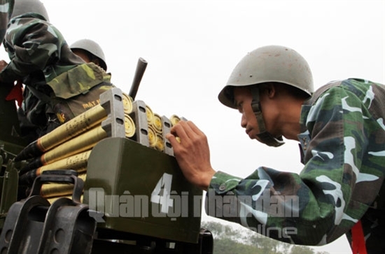 Xác định bắn đạn thật là nhiệm vụ đòi hỏi tính khẩn trương song cũng vô cùng tỷ mỉ, chính xác, nên các pháo thủ hết sức thận trọng trong quá trình thao tác. Trong ảnh: Một pháo thủ kiểm tra đạn trong buồng nạp.