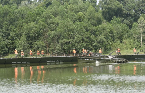 Bộ đội hạ thủy và lắp ghép 2 đốt cầu PMP thành cầu phao để vận chuyển người và phương tiện từ gò đất bị nước lũ cô lập đến nơi an toàn