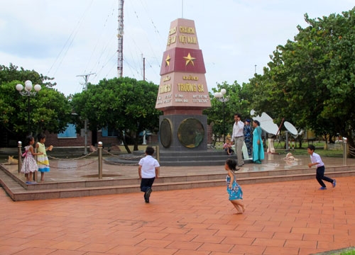 Các em bé tung tăng chạy nhảy và nô đua bên cột mốc chủ quyền