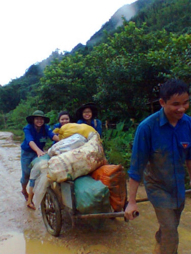 Giúp bà con thu hoạch ngô thì trời mưa to, nhưng các bạn vẫn nở nụ cười.