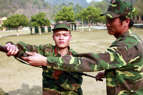 Trung úy Nguyễn Đức Tuấn, Trung đội trưởng Trung đội 1, Đại đội 1 (bên phải) sửa tập động tác đánh báng đầu cho chiến sĩ. Đây là một tư thế dùng báng súng tiểu liên AK đánh vào đầu đối phương khi cận chiến thường được các chiến sĩ quân đội ta áp dụng hiệu quả trong tác chiến từ xưa đến nay.