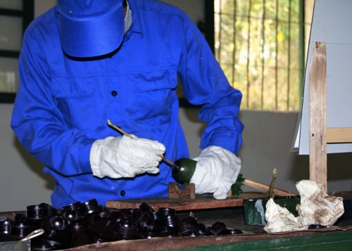 Lau sạch lần cuối và chuẩn bị đóng nắp phòng ẩm. Trước đó, đã có hai kỹ thuật viên lau chùi bảo quản vỏ đạn bằng giẻ sạch và khô.