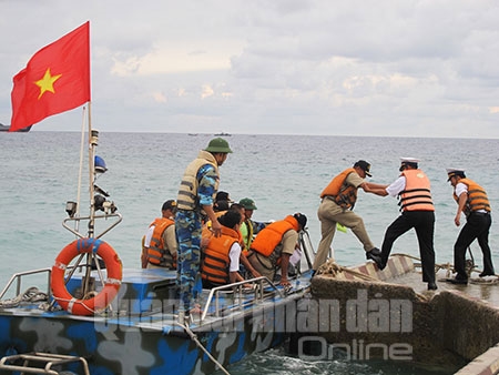 Chiếc xuồng đầu tiên của Hải quân Việt Nam đón các thành viên đoàn Phi-líp-pin vào đảo Song Tử Tây. Mỗi nước cử 40 đại diện tham gia cuộc giao lưu.