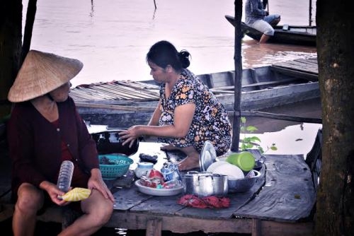 Trong vùng lũ, người dân vẫn bơi xuồng đến thăm hỏi, trò chuyện với nhau.