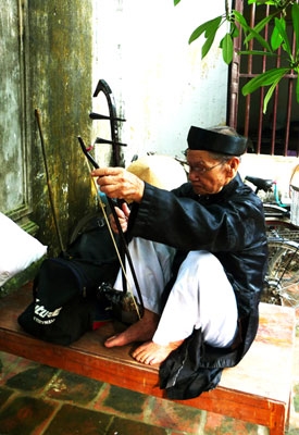 Một nghệ nhân chuẩn bị nhạc cụ trình diễn trong lễ hội.