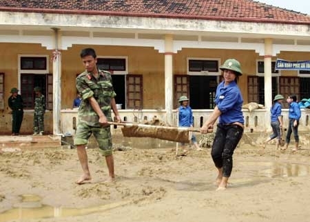 Cùng sinh viên tình nguyện dọn bùn tại trường tiểu học Đức Lĩnh