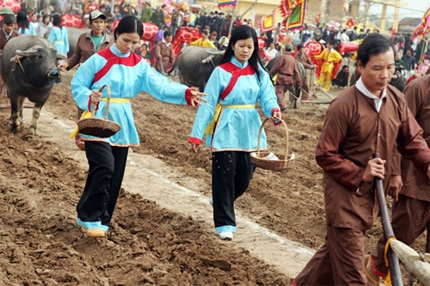 Theo sau đường cày là các cô gái gieo hạt giống cầu cho vụ mới bội thu.