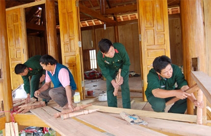 Cán bộ, nhân viên Đội xây dựng cơ sở số 6 (Ban CHQS Quế Phong) giúp dân dựng lại nhà ở khu tái định cư bản Piềng Cu, xã Tiền Phong, Quế Phong.