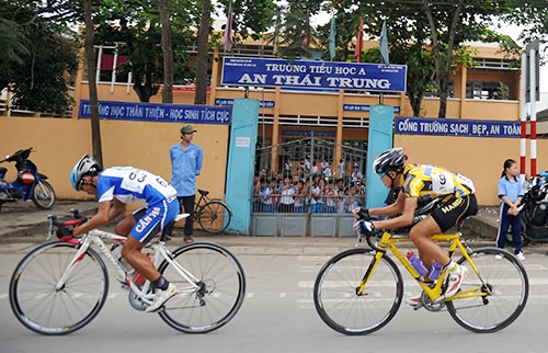 Các em học sinh tiểu học An Thái Trung A, huyện Cái Bè (Tiền Giang) háo hức xem đoàn đua băng qua.
